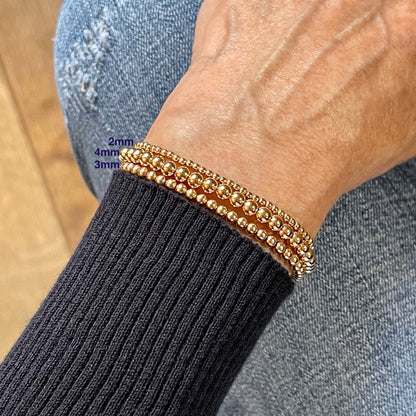 Rose gold bracelets for women with 2mm, 3mm, and 4mm beads in 14K gold fill on elastic stretch.