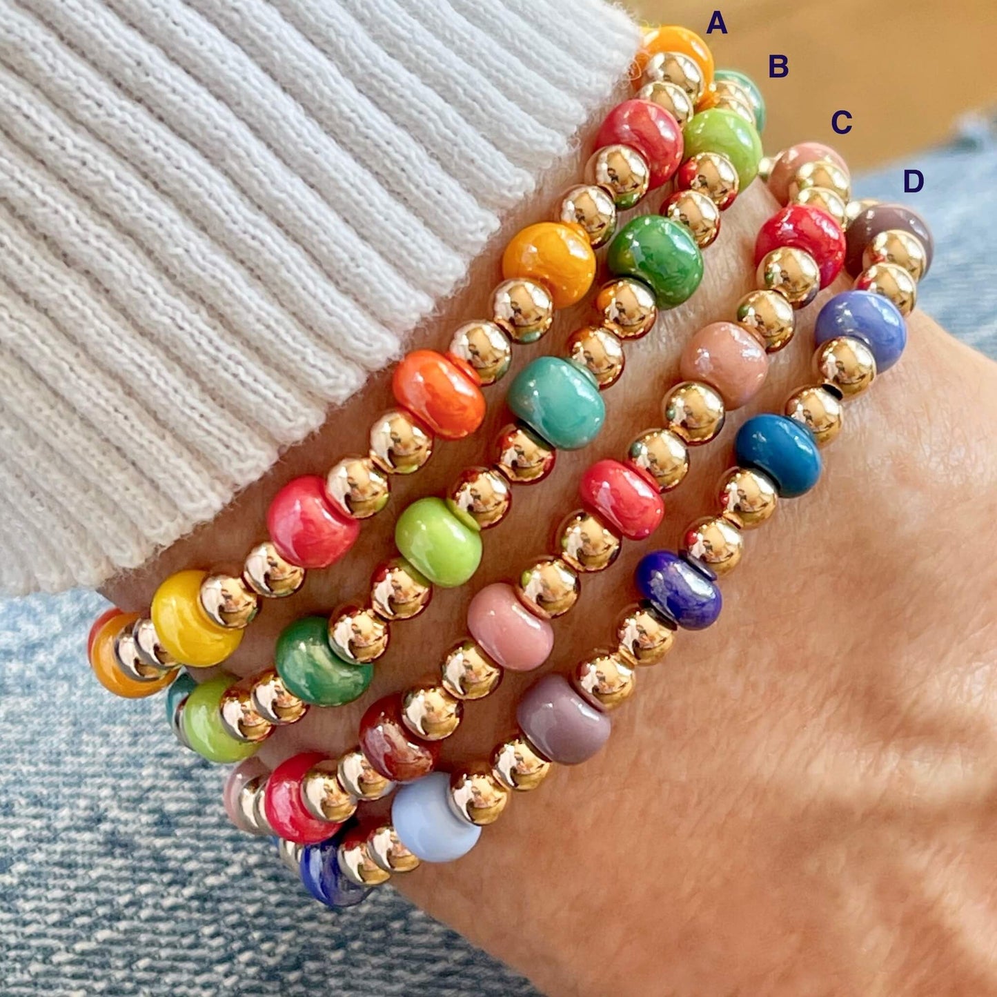 Beaded bracelets with rose gold-filled beads and monochromatic mixes of glass beads in reds, oranges, greens, and blues.