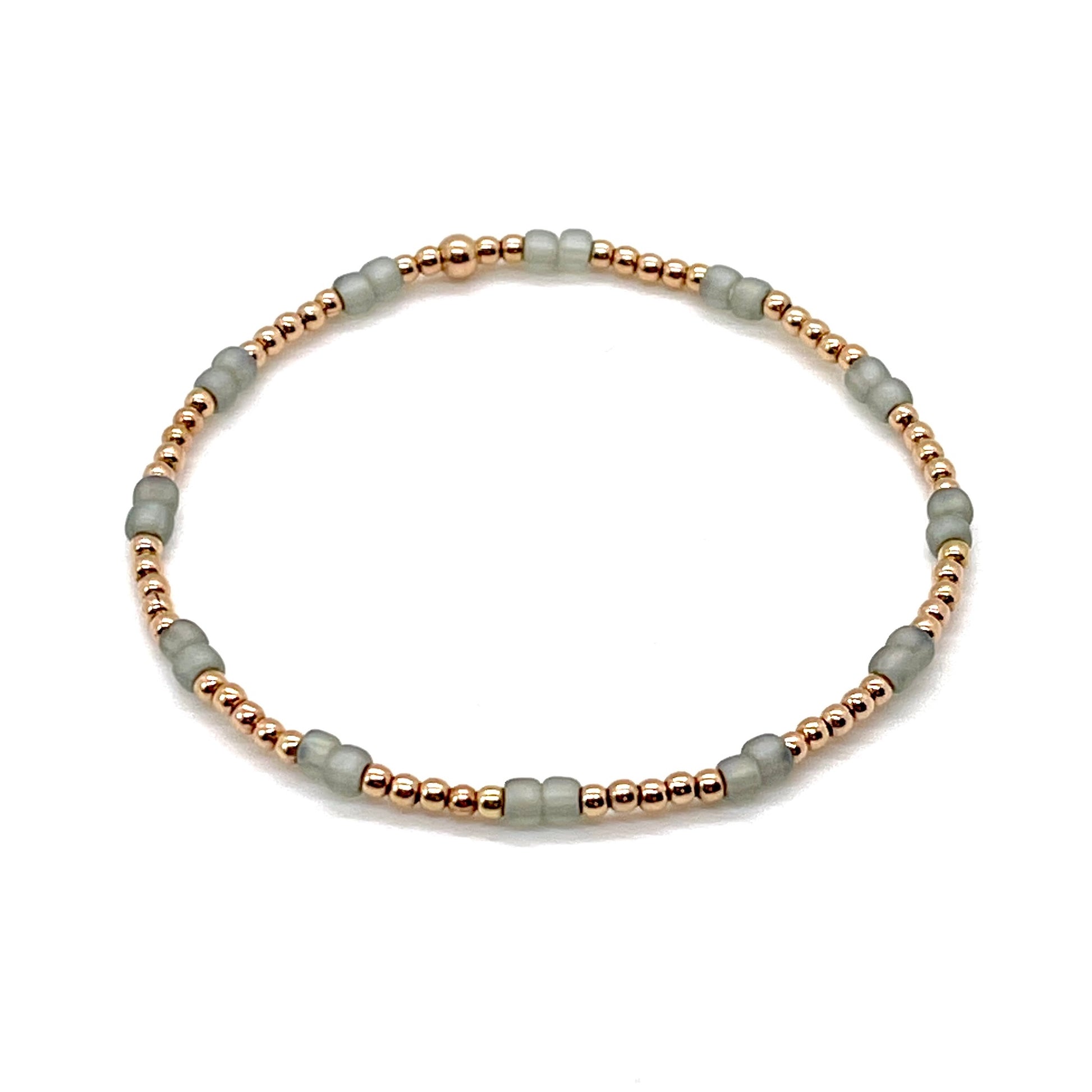 Rose gold stretch bracelet with 2mm 14K gold filled beads and matte green/gray seed beads.