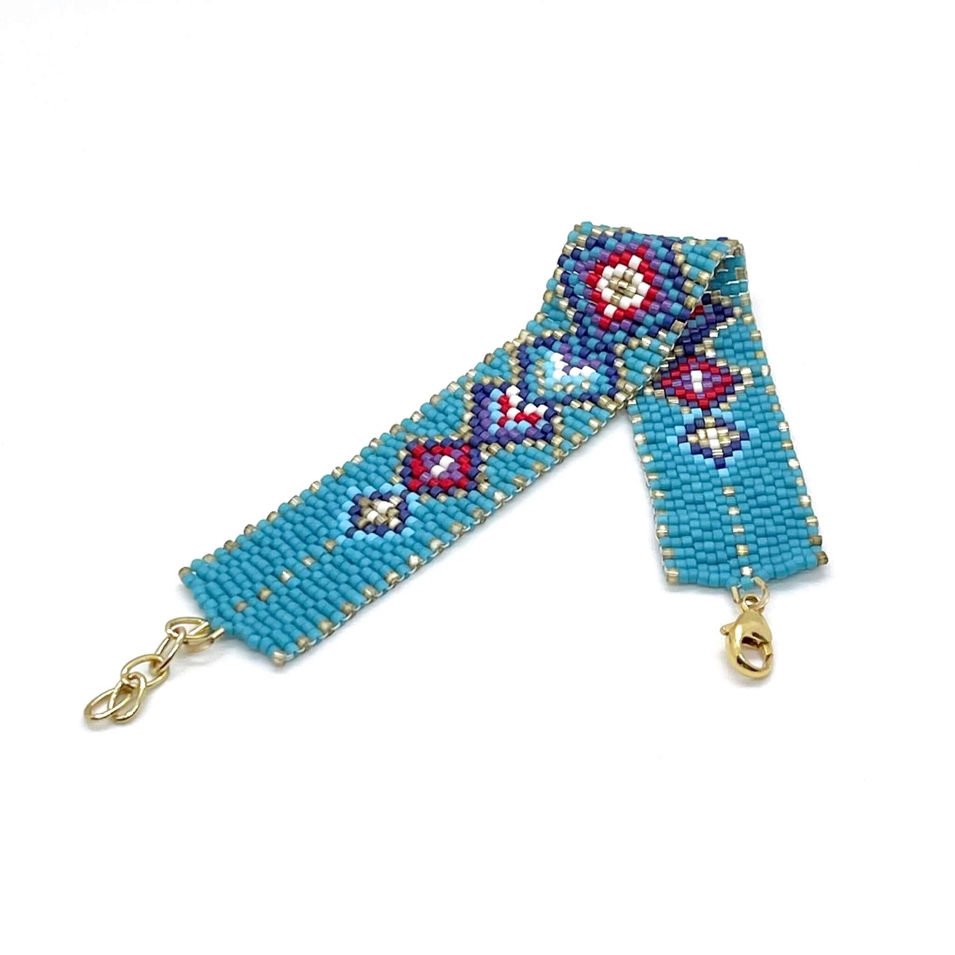 A santa-fe inspired turquoise, red, gold, and purple peyote stitch bracelet with a diamond pattern.