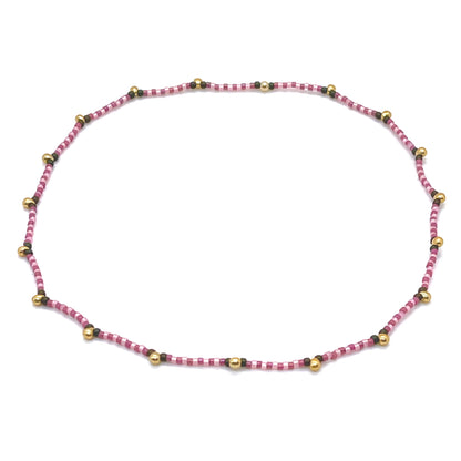Seed bead choker stretch necklace with pink and berry seed beads and gold-tone droplet beads.