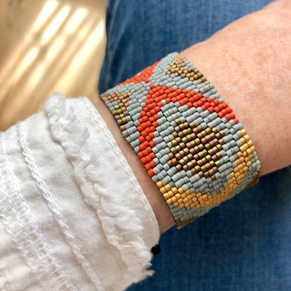 Seed bead wide bracelet band with orange, gold, and grey seed beads.