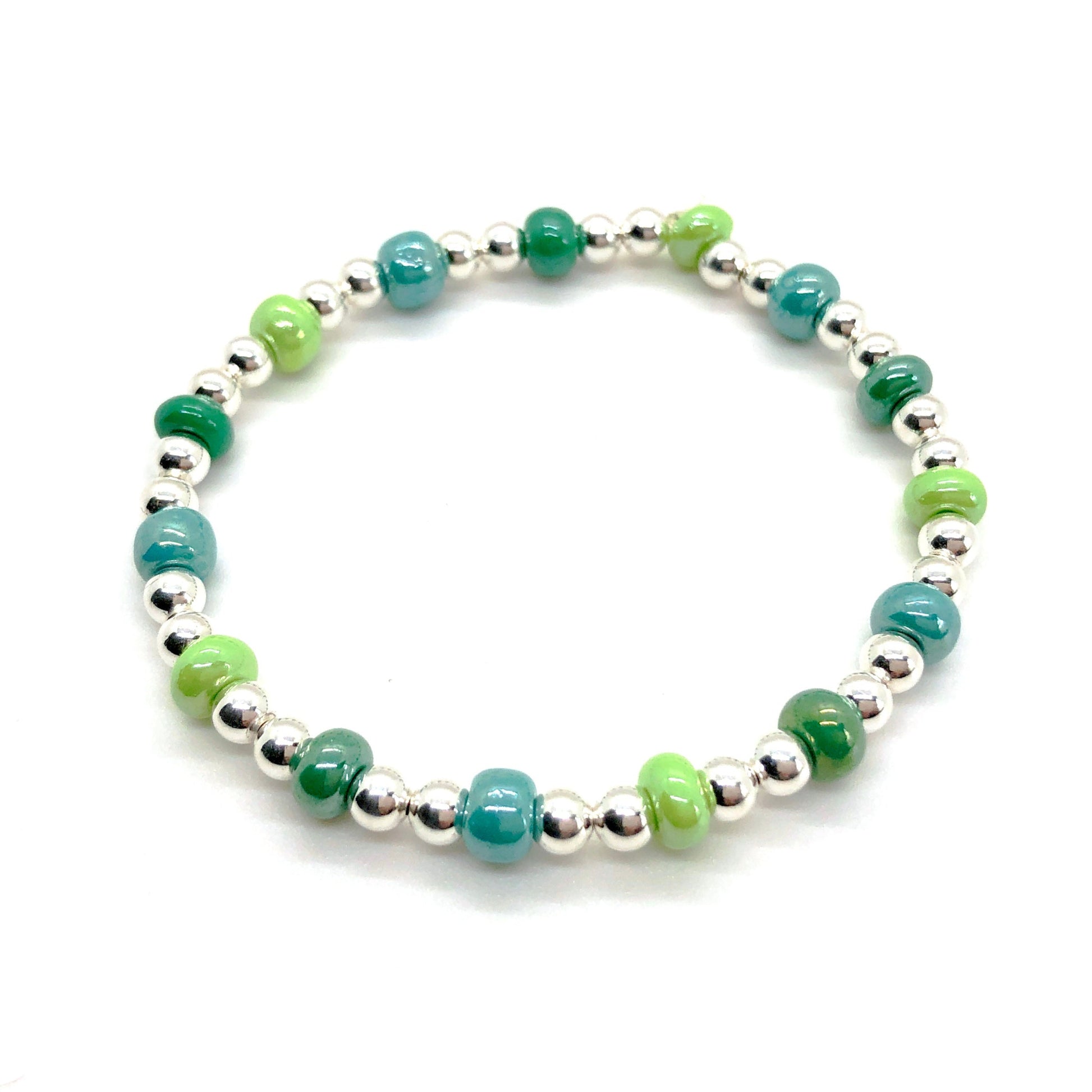 Silver stretch bracelet with 4mm sterling silver balls and alternating chunky glass beads in shades of green.