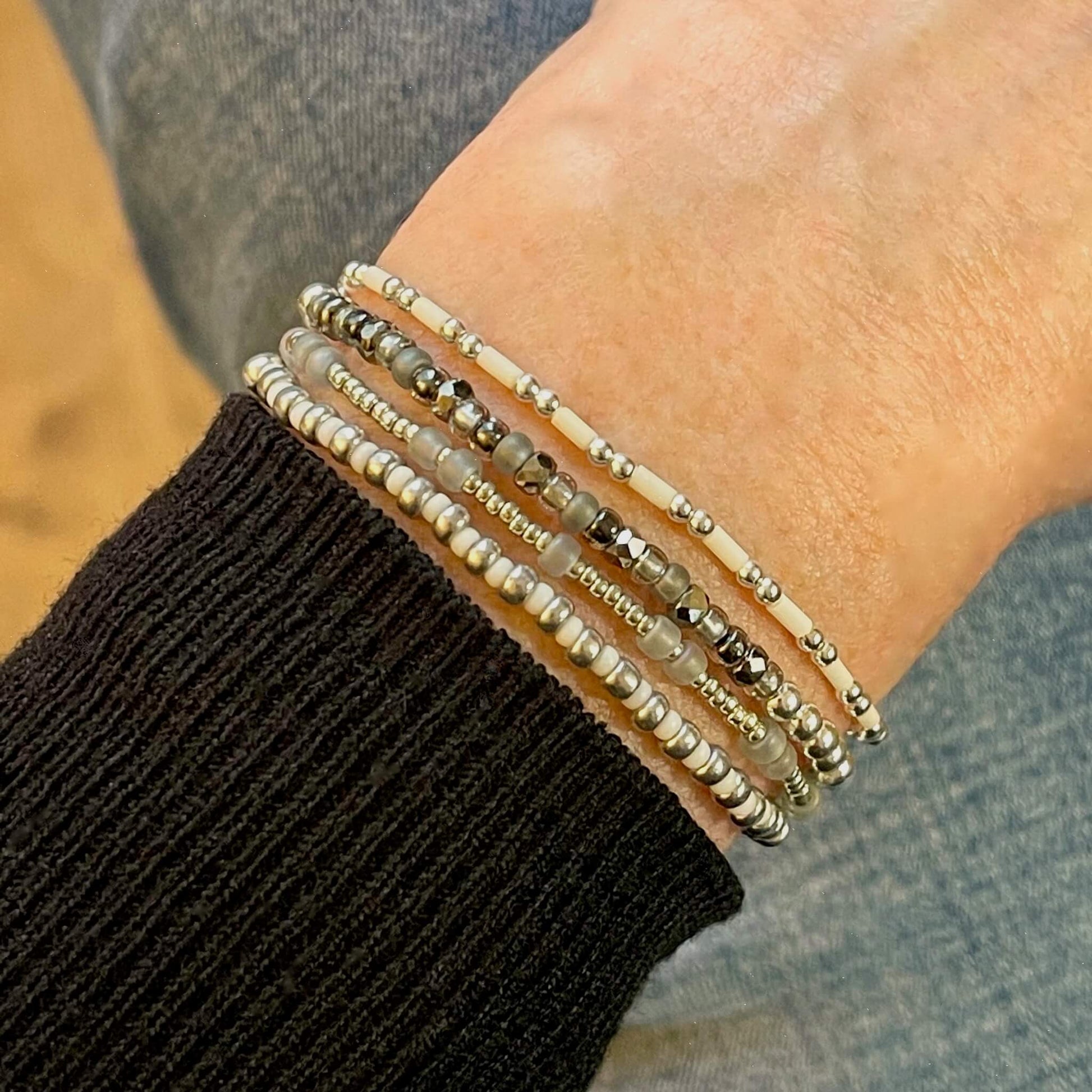 Silver seed bead bracelet stack of 4 stretch bracelets for women with grey and white accents. Handmade in NYC.