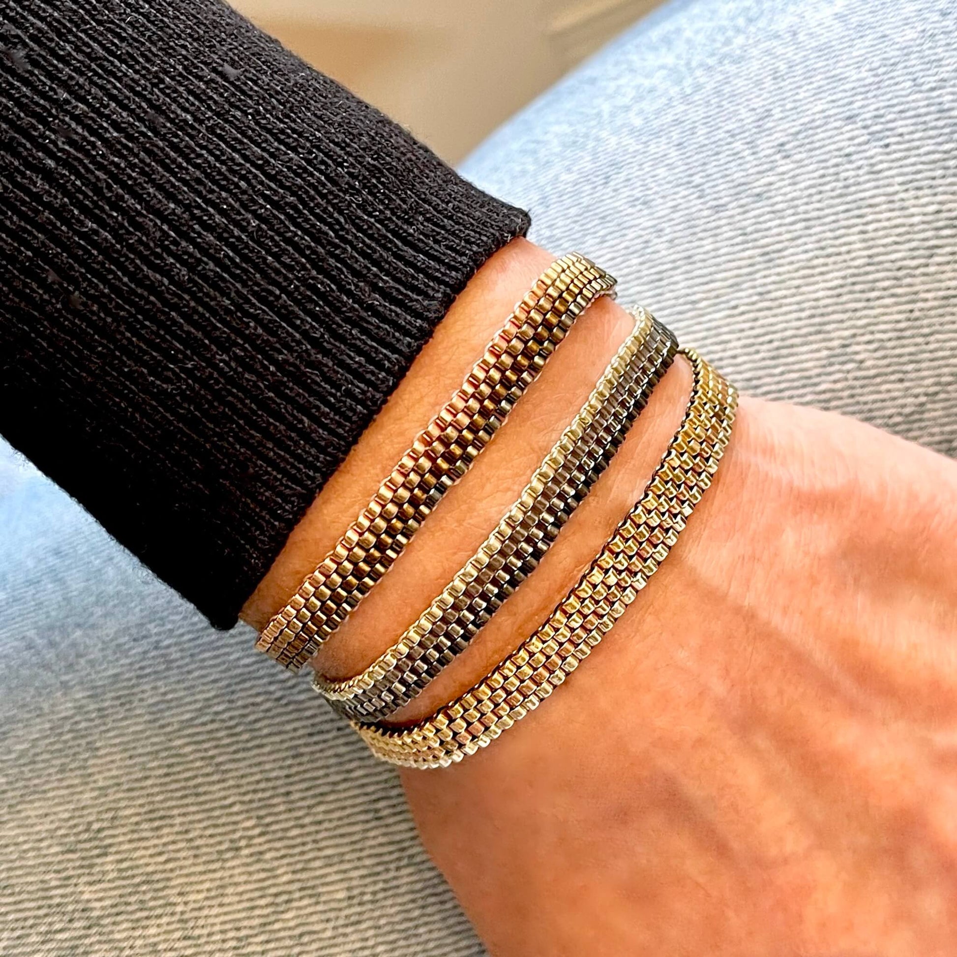 Three thin woven metalllic seed bead boho bracelets in various color combinations such as gunmetals, bronzes, or gold tones.