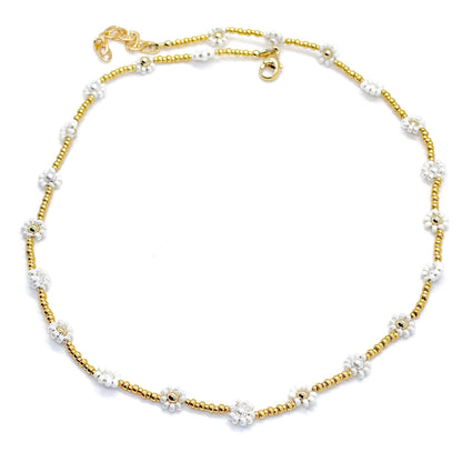White flower necklace with a gold-tone seed bead chain and gold-fill and crystal pearls center beads in the flowers.