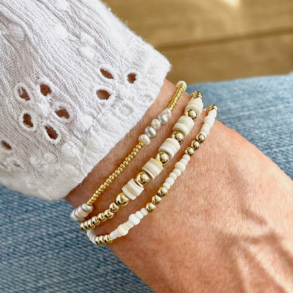 White and gold beaded stretch bracelet stack with freshwater pearls, heishi, 14K gold filled, and glass seed beads.