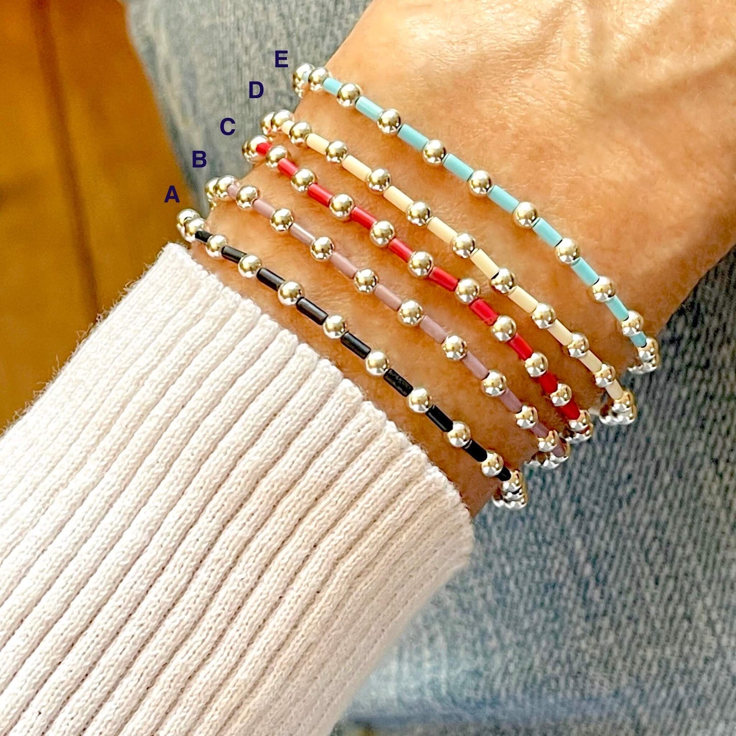 Women's beaded bracelets with seed beads in slate, purple, red, ivory, and blue, alternating with silver 3mm ball beads. Stretchy.