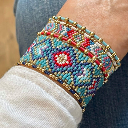 Woven and stretch bright red and blue beaded bracelet stack of 6. With 2 peyote stitch bracelets and 4 gold and seed bead stretch bracelets.