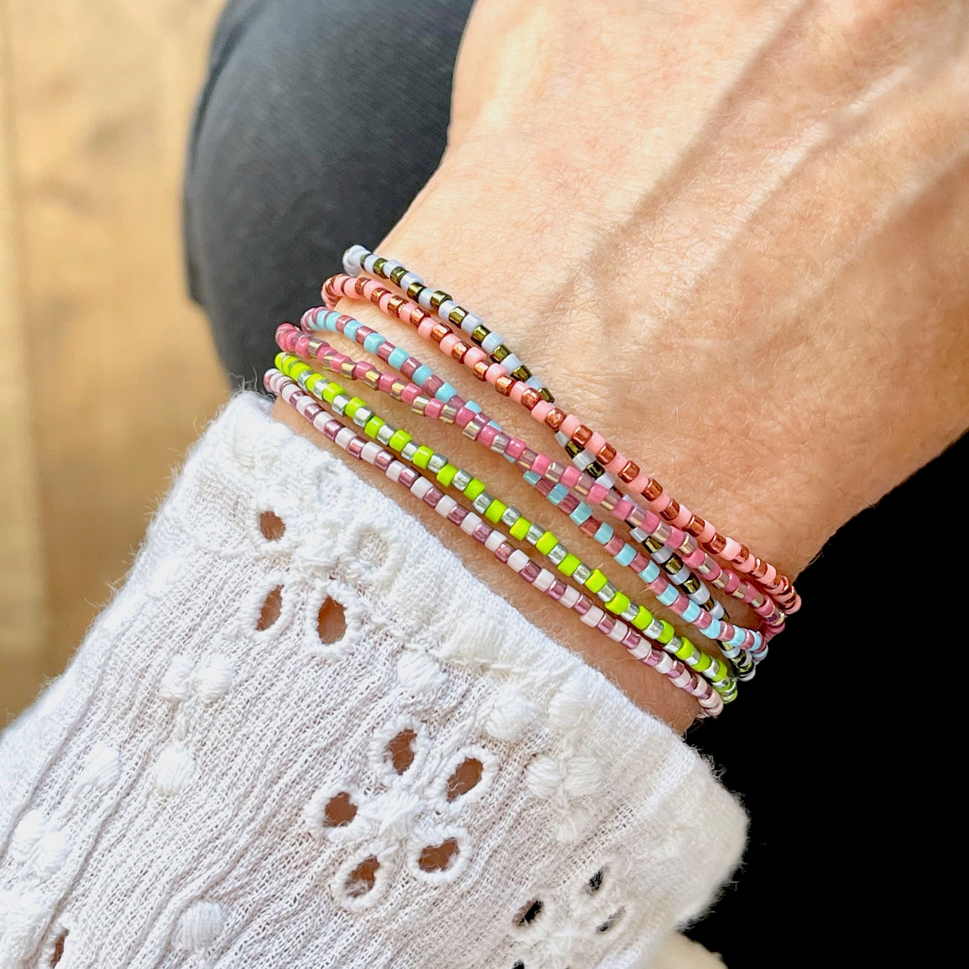 Beaded wrap with dainty citrus colored and metallic seed beads on a stretch cord that wraps the wrist 6 times.