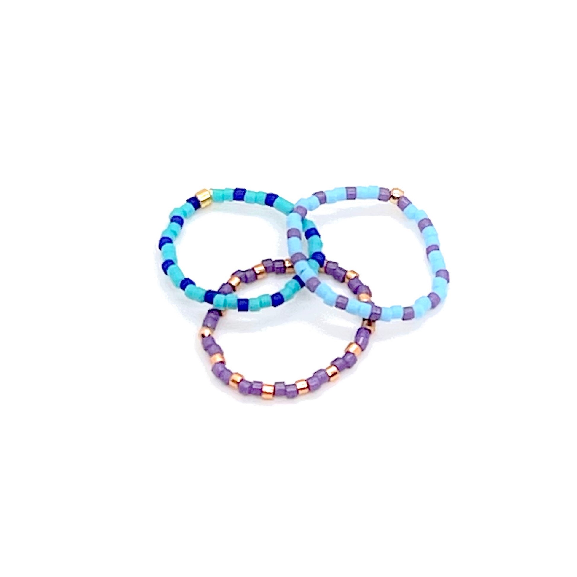 Beaded stretch ring set of 3 with metal-tone, and alternating purple, turquoise, and cobalt blue Miyuki Delica seed beads.