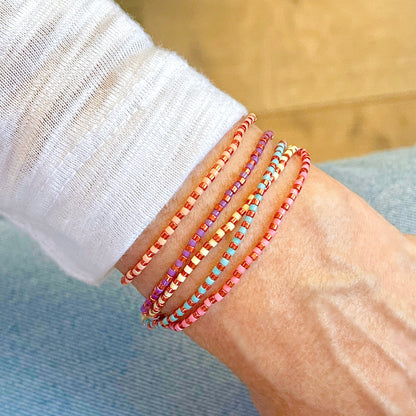 Multi strand beaded bracelet with copper and colorful seed beads on a stretch cord.