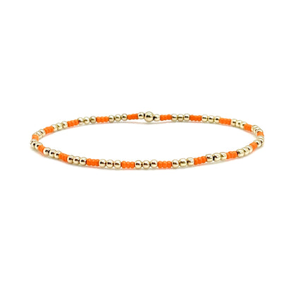 Gold beaded bracelet with delicate orange glass seed beads and 2mm 14K gold filled beads on elastic.