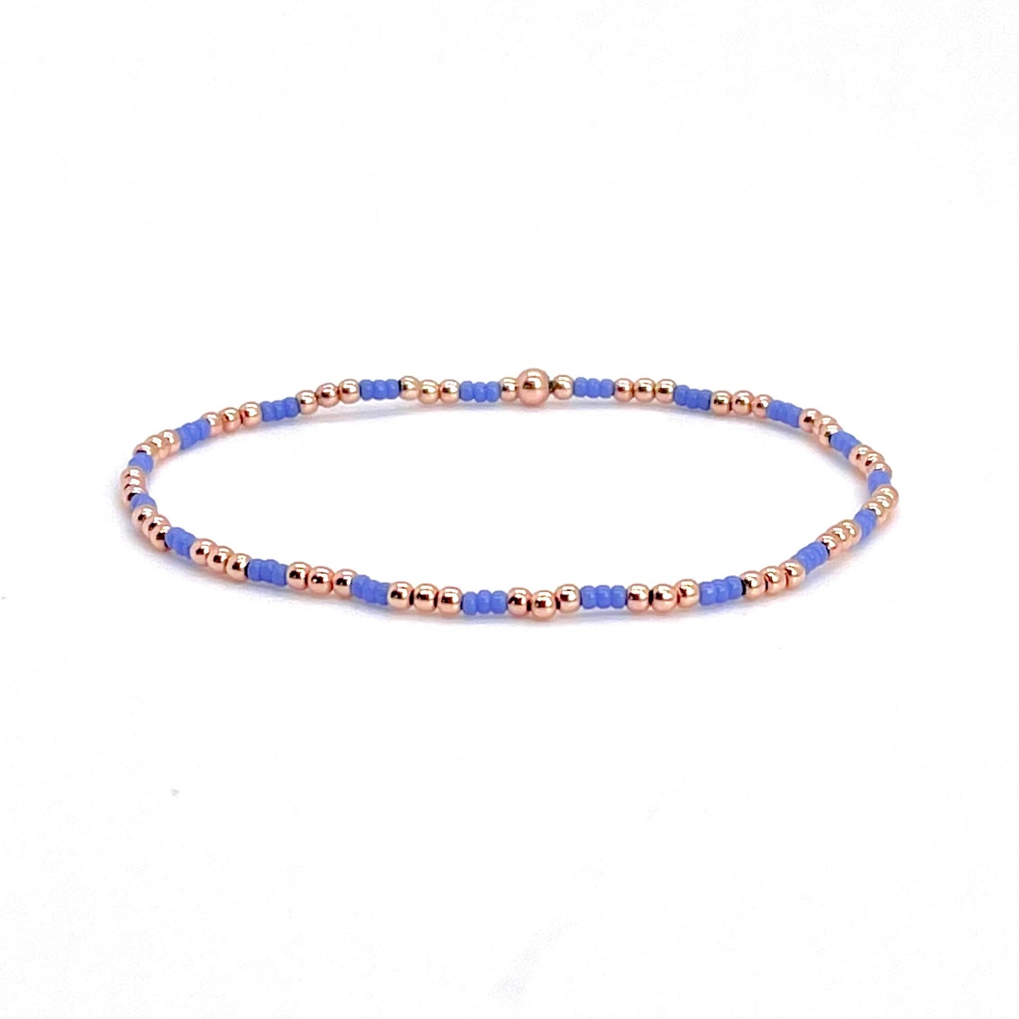 Rose gold bracelet for women with small periwinkle blue seed beads on stretch cord.