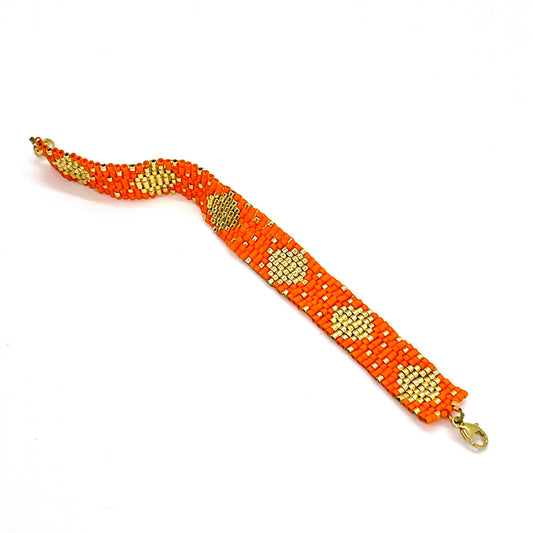 Fun, colorful orange and gold wide hand woven beaded wristband bracelet with dainty tiny glass seed beads.