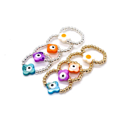 Evil eye rings with 3mm gold-filled and sterling silver ball stretch bands and colorful  flower and evil eye center shell beads.