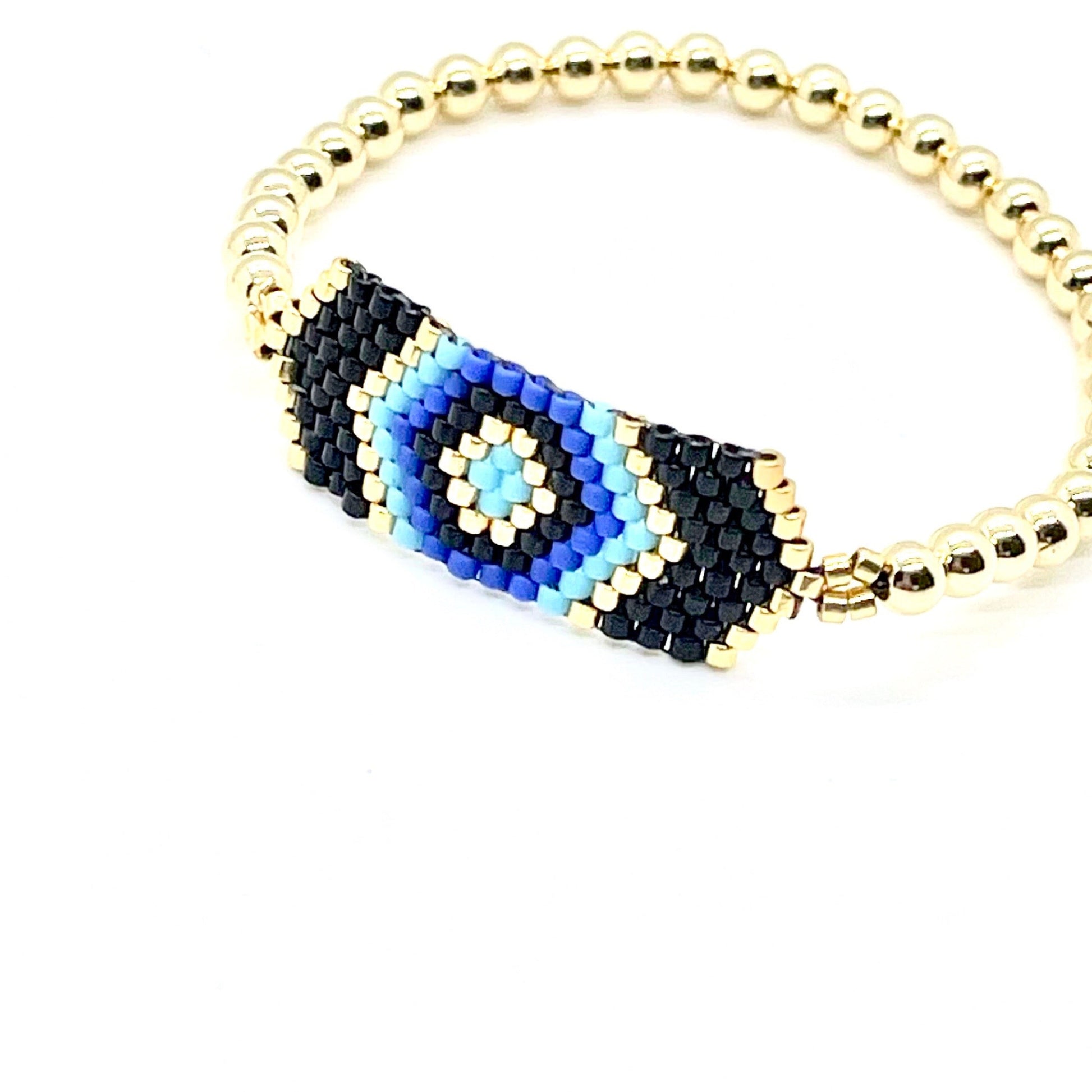Evil eye beaded bracelet. Black evil eye with blue and gold beads on elastic stretch.