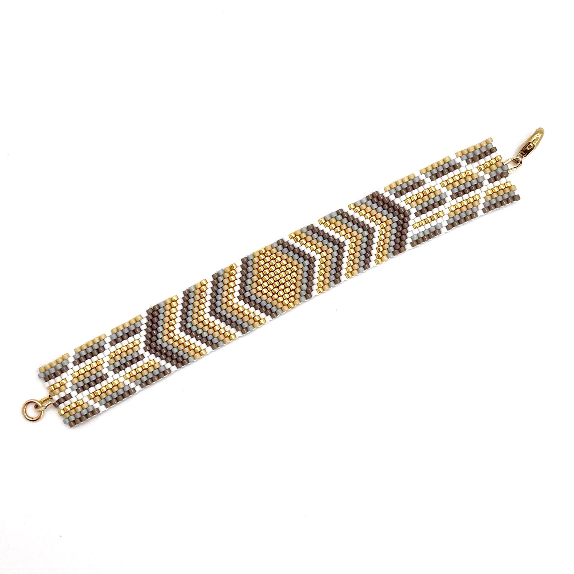 Flat beaded bracelet woven with gold, white, and tan tiny beads. A fun and stylish beach or pool accessory.