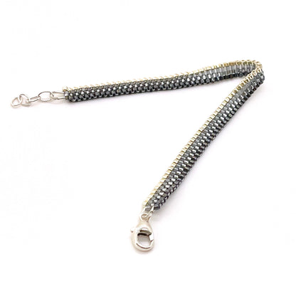 Horizontal stripes black gunmetal beaded woven bracelet with ombre stripes from silver to black and a sterling silver clasp.