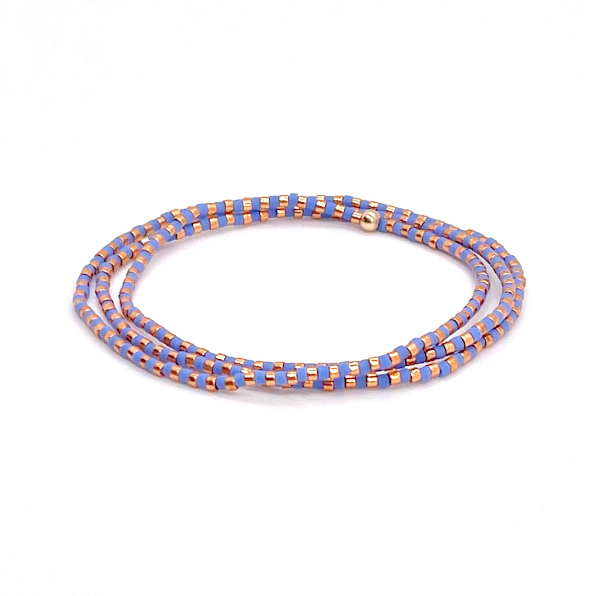 Beaded wrap bracelet with periwinkle blue and rose gold-tone seed beads on stretch cord.
