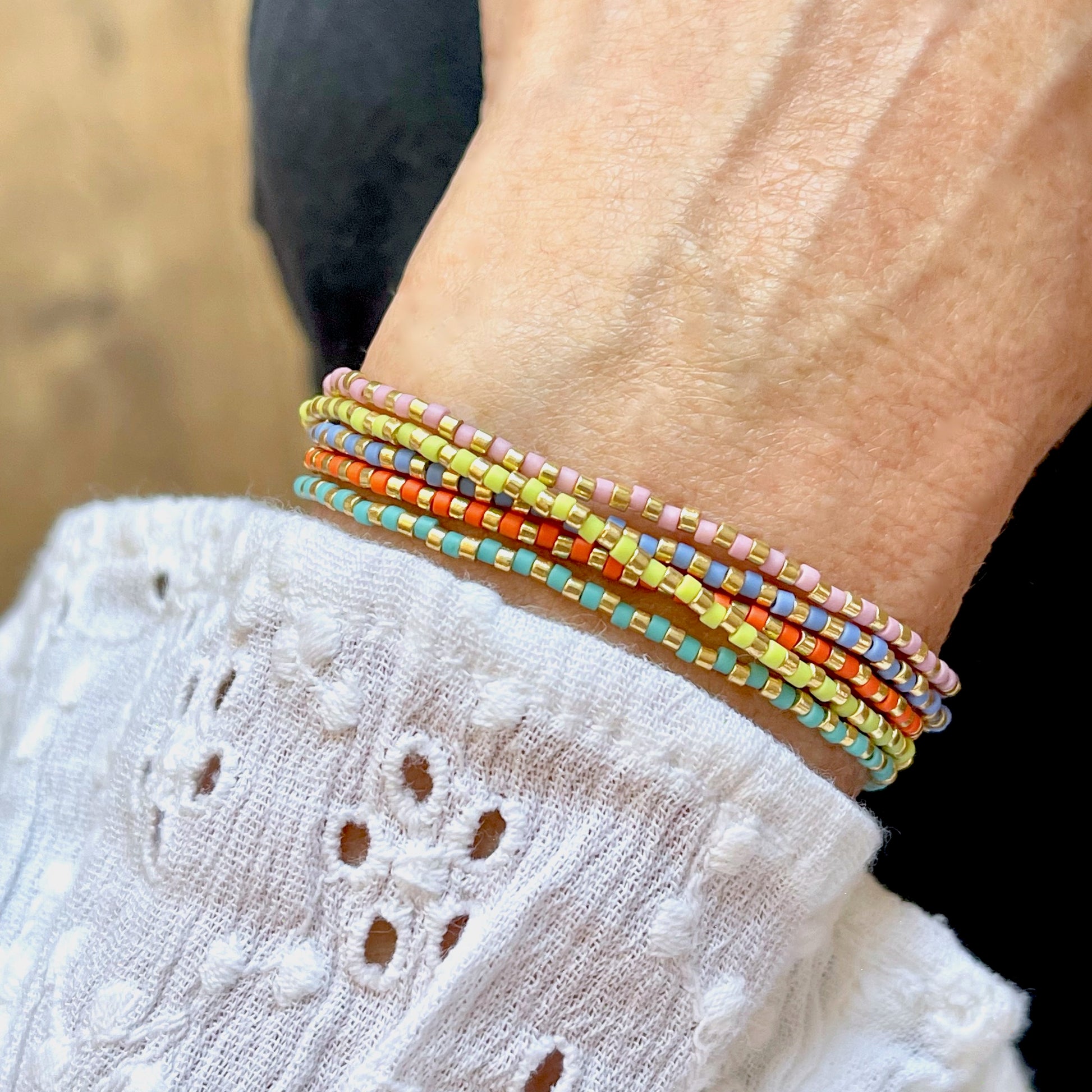 Multi strand bracelet with dainty fruity color and gold seed beads on a stretch cord.