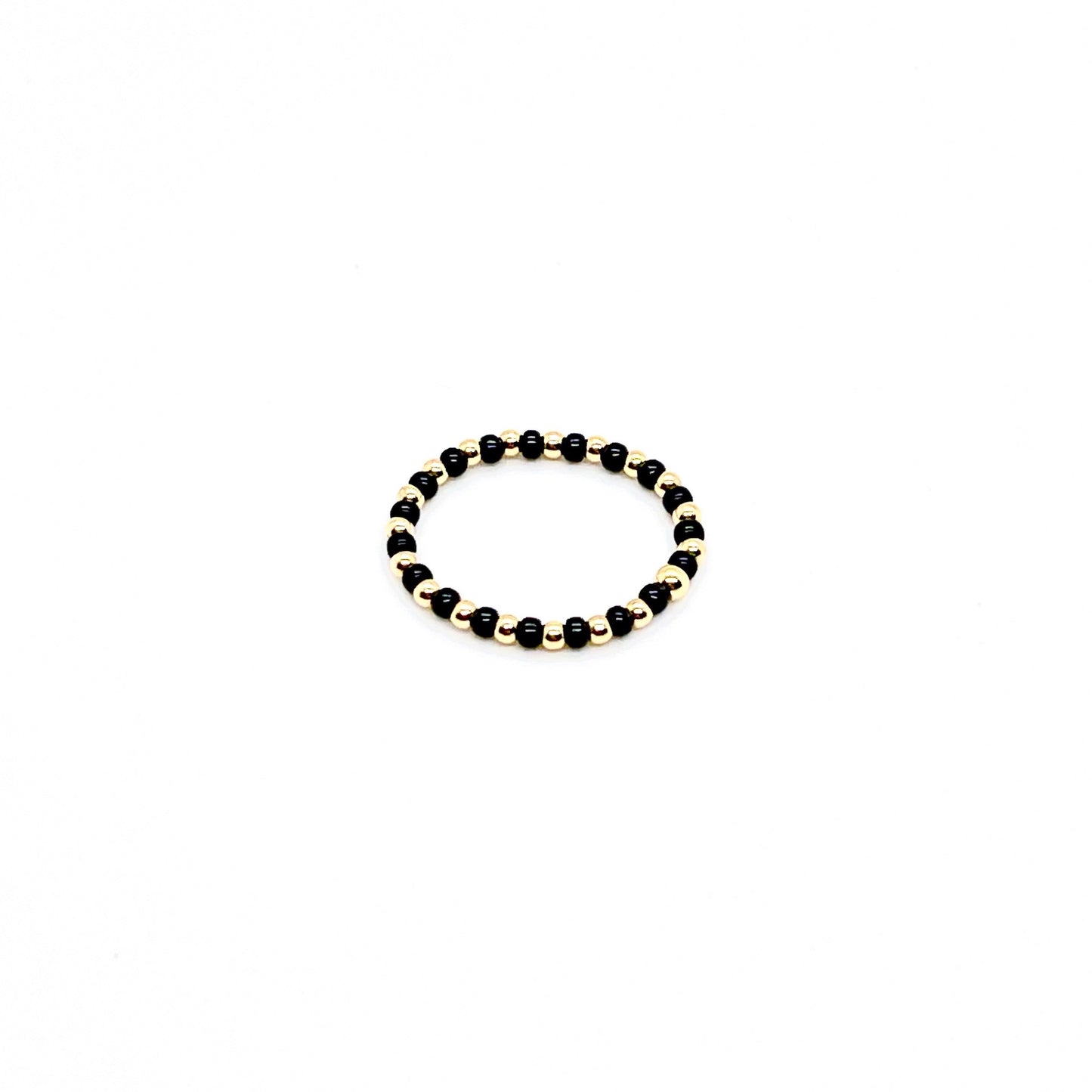 Seed bead ring with alterating black and 2mm 14k gold filled beads on stretch cord.