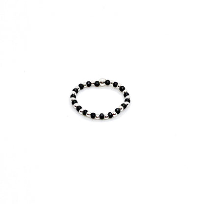Seed bead ring with alterating black and 2mm sterling silver beads on stretch cord.