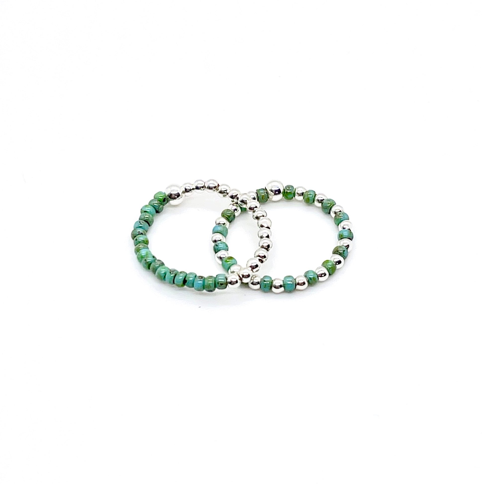 Stretch ring set with turquoise color block and seed beads alternating with 2mm sterling silver balls on stretch cord.