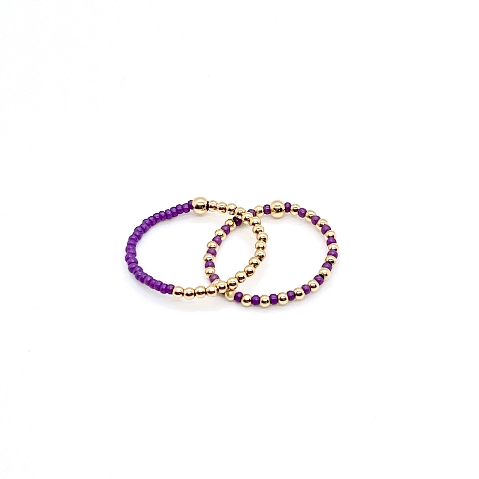 Stretch ring set with purple color block and seed beads alternating with 2mm gold balls on stretch cord.