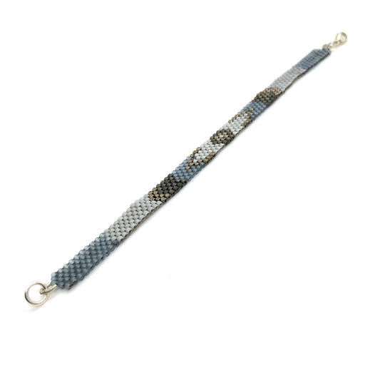 Thin boho beaded bracelet with blue, slate, gray, and gunmetal, tiny glass Miyuki seed beads, in a peyote stitch.