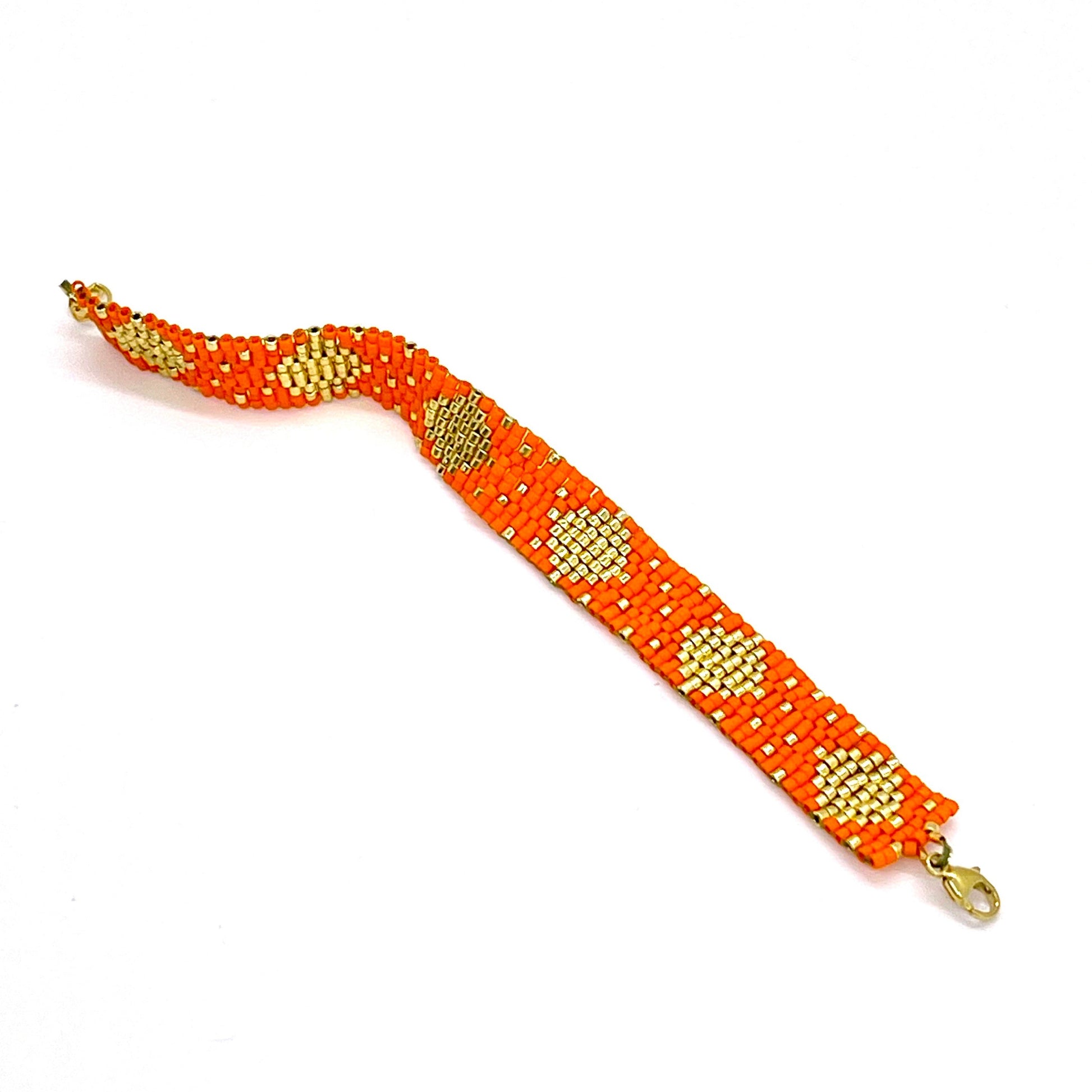 Two-tone bracelet with orange and gold-tone glass seed beads in a handwoven triangle pattern.